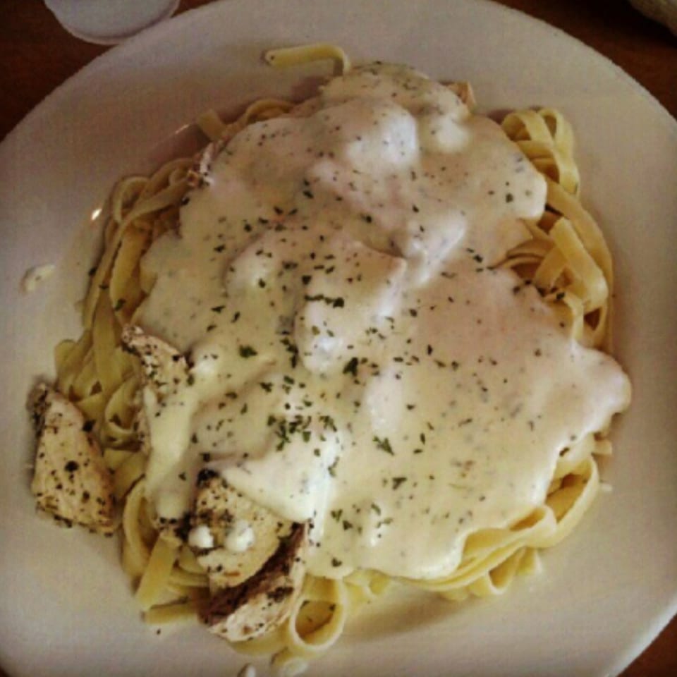 Fettuccine Alfredo with chicken and herbs, a classic Italian dish from The Grinders & Spaghetti House.
