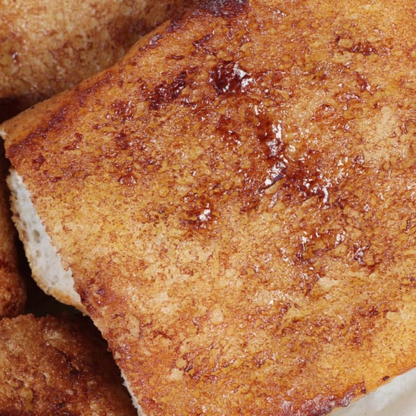 Close-up of golden-brown garlic bread with visible butter and seasoning, from The Grinders & Spaghetti House.