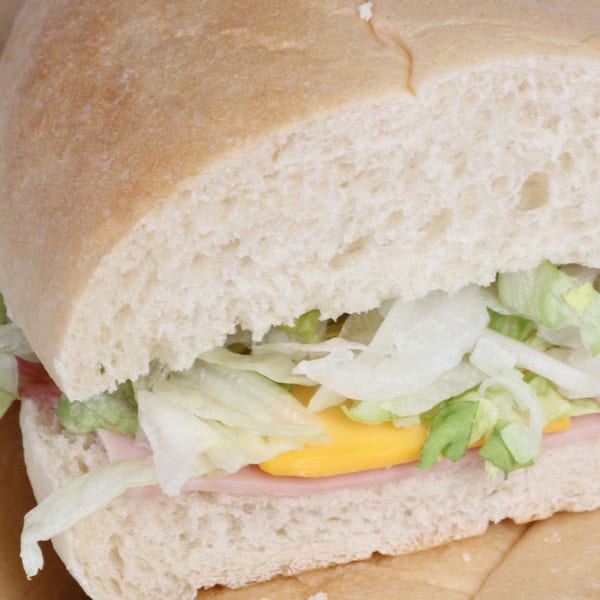 Close-up of a Grinder sandwich from The Grinders & Spaghetti House, filled with ham, cheese, and lettuce.
